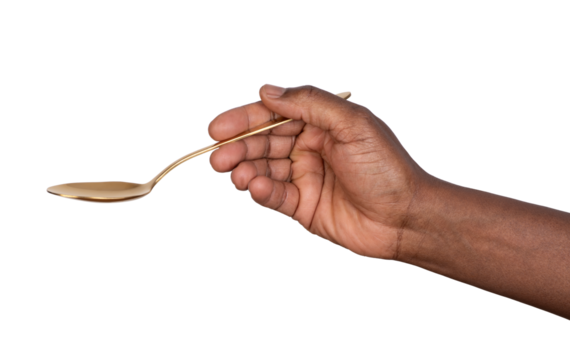 Hand holding a gold tablespoon isolated on white or transparent background	