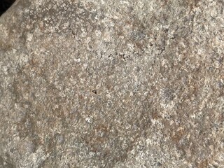 Close-up shot of a rough, textured stone surface. The image showcases the natural grain and imperfections of the rock