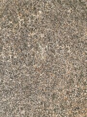 Close-up shot of a rough, textured stone surface. The image showcases the natural grain and imperfections of the rock