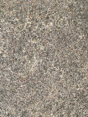 Close-up shot of a rough, textured stone surface. The image showcases the natural grain and imperfections of the rock