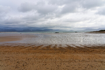 Wide expanse of Newborough Beach, Anglesey, at low tide on an overcast autumn morning.