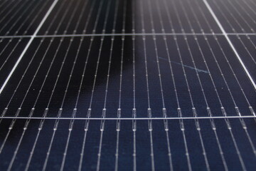 Close-up solar photovoltaic panel surface detailed grid pattern of individual solar cells with metallic conductors. Dark blue-black silicon cells renewable energy electricity generation technology.