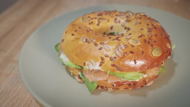 Close up of a salmon and avocado bagel spinning on a plate
