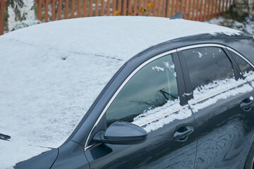 Close-up of car roof and windows covered with snow in winter
