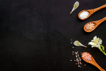 Fototapeta na wymiar Spa flat lay with many spoons full of sea salt and scrubs, top view. Body care cosmetics