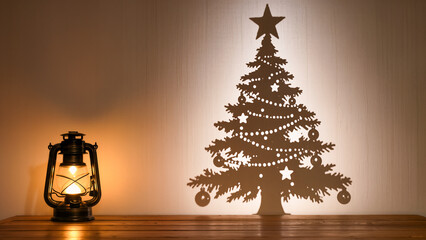 Christmas silhouette. An antique kerosene lantern illuminates a shadow projection or cutout of a Christmas tree on the wall.