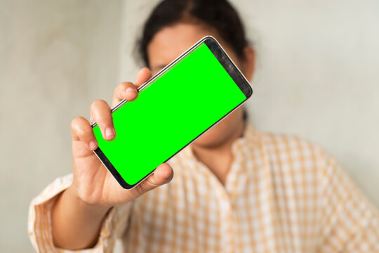 Person Holding Smartphone with Green Screen Display