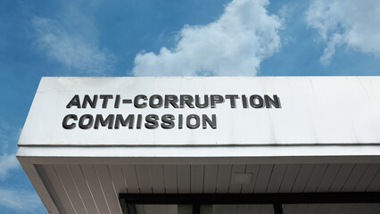 Anti-Corruption Commission word sign displayed on building facade under blue sky, representing a government office for ethics, integrity, and law enforcement