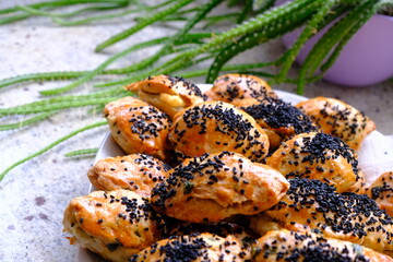 Delicious homemade black cumin and cheese pastries. Cactus ivy in the background. Parsley and cheese breakfast pastries. Ramadan iftar menu. Traditional Turkish pastries.