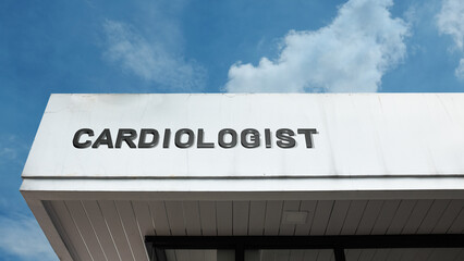 Cardiologist word sign displayed on a building under a clear blue sky, representing heart care, medical services, healthcare, cardiology practice, and hospital facilities