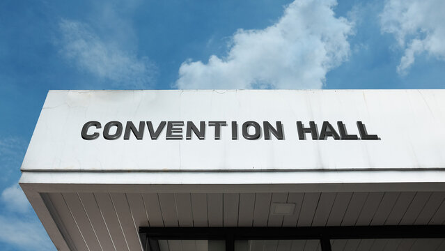 Convention Hall word sign displayed on a building under a clear blue sky, representing events, meetings, conferences, exhibitions, and large-scale public or business gatherings