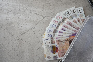 Silver partmone with british pound money. United Kindom bills in leather wallet for commerce concept.