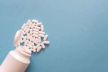 Tabletten or pillen in white package on the blue background with place for text.