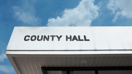 County Hall word sign displayed on a building under a clear blue sky, representing local government, civic administration, public services, and municipal facilities