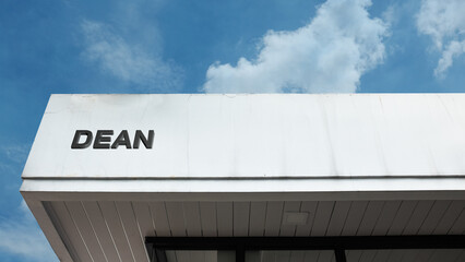 Dean word sign on a building under a clear blue sky, representing leadership, education, administration, management, academic guidance, and institutional roles