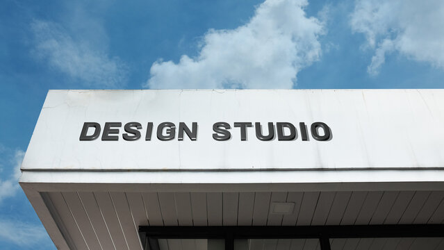 Design Studio word sign on a building under a clear blue sky, representing creativity, art, design work, professional studio, architecture, and visual arts