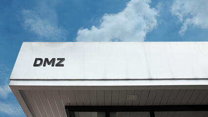 DMZ word sign displayed on a building under a clear blue sky, symbolizing the demilitarized zone, international borders, and peaceful separation between regions or countries.