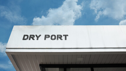 Dry port word sign displayed on a building with a blue sky background, representing logistics, transportation, and cargo handling services.
