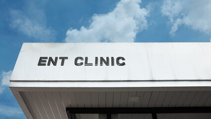 ENT Clinic sign displayed on a building against a clear blue sky, symbolizing specialized healthcare, otolaryngology services, medical treatment, and hearing and voice care