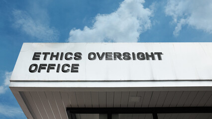 Obraz premium Ethics Oversight Office sign displayed on a building against a clear blue sky, symbolizing compliance, integrity, governance, accountability, professional standards, and regulation