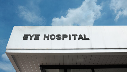 Eye Hospital sign displayed on a building against a clear blue sky, symbolizing specialized medical care, ophthalmology, vision treatment, surgery, and public health services