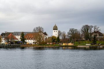 Fraueninsel with the Benedictine monastery Frauenchiemsee and local buildings on a cloudy day in autumn