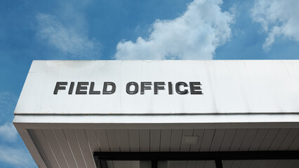 Field Office sign displayed on a building against a clear blue sky, symbolizing branch location, remote administration, local services, government presence, and operations