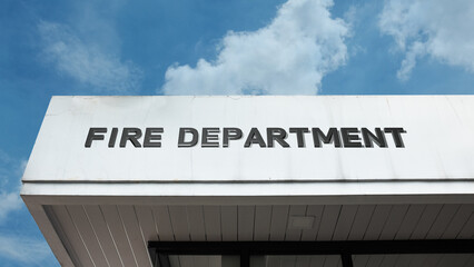 Fototapeta premium Fire Department sign displayed on a building against a clear blue sky, symbolizing emergency services, rescue operations, public safety, community protection, and rapid response