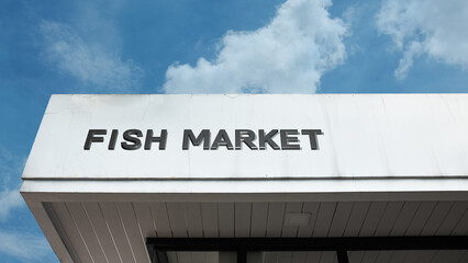 Fish Market sign displayed on a building against a clear blue sky, symbolizing seafood commerce, retail sales, fresh catch, commercial trade, and marine food supply