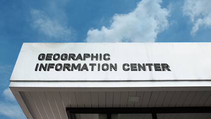 Obraz premium Geographic Information Center sign displayed on a building against a clear blue sky, symbolizing mapping, spatial data, GIS technology, earth science, and research facility