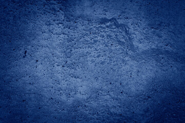 Close-up of rough, textured rock surface with deep cracks and varying shades of blue