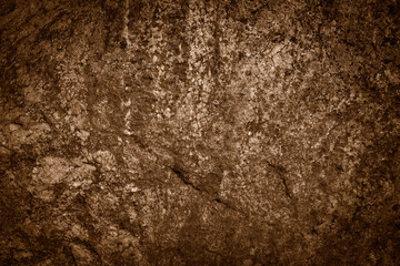 Close-up of rough, textured rock surface with deep cracks and varying shades of brown