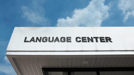 Obraz premium Language Center sign on a building against a clear blue sky, symbolizing educational facility, communication, linguistic skills, cultural exchange, and growth