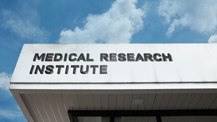 Fototapeta premium Medical Research Institute sign on a building against a clear blue sky, symbolizing scientific discovery, advanced studies, healthcare innovation, science, and development