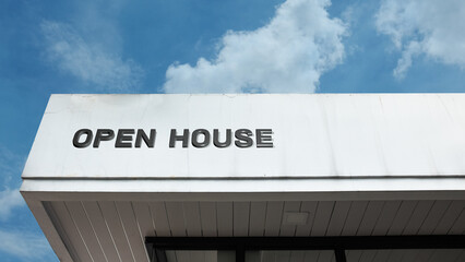 Open House word signage displayed on a residential building under a blue sky, symbolizing real estate, property viewing, sales event, and housing market