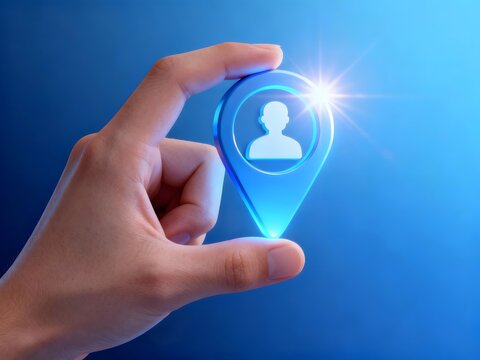 Hand holding a location pin with a person icon a concept for finding people isolated on blue background