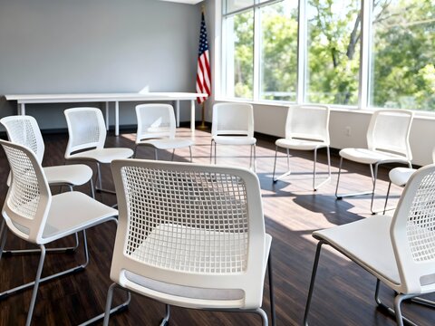 Circle of white chairs in a bright room arranged for a meeting or therapy session with an American flag in the background