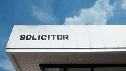 Solicitor word signage on a professional legal building under a blue sky, symbolizing individual legal counsel, law practice, professional advice, justice, UK legal services, and client consultation