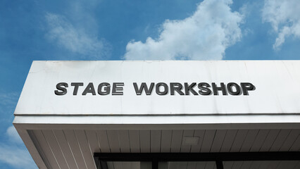 Obraz premium Stage Workshop word signage on a theatrical or educational building under a blue sky, symbolizing dramatic arts, performance training, acting studio, theater production, set design, and creative instr