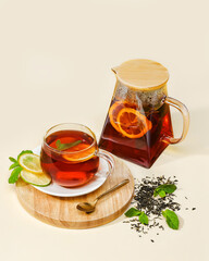 Glass Teapot and Cup of Herbal Black Tea with Citrus and Mint