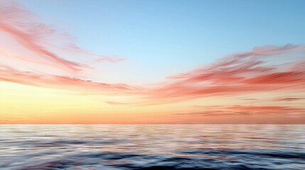 Obraz premium A serene ocean scene at sunset, with the sky painted in hues of orange, pink, and blue, reflecting on the rippling water.
