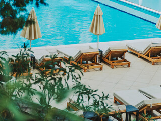 Empty sun loungers by the pool at a sea resort