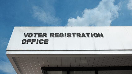 Voter Registration Office word signage on a government building under a blue sky, symbolizing democracy, civic rights, election administration, and public engagement