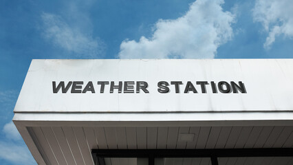 Obraz premium Weather Station word signage on a technical building under a blue sky, symbolizing meteorology, climate, prediction, science, data collection, and atmospheric monitoring