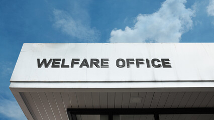 Welfare Office word signage on a government building under a blue sky, symbolizing public aid, social security, community support, assistance, and relief programs