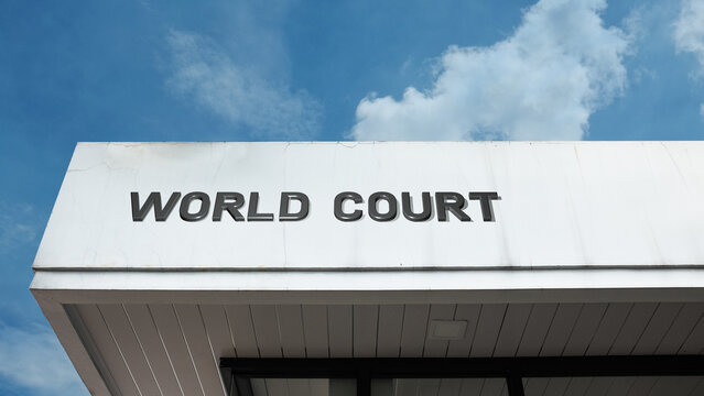 World Court sign displayed on its building facade against a clear blue sky, symbolizing international justice, global law, legal arbitration, human rights, and peaceful dispute resolution
