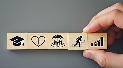 Hand arranging wooden blocks with education, faith, family, progress icons Keywords: education