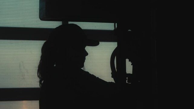 Silhouette of Female Worker Operating Industrial Machine