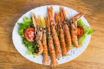 Grilled Scampi Seafood Plate with Fresh Salad on Wooden Table
