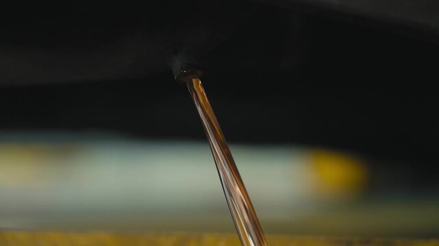 Close-Up of Clean Engine Oil Draining From Vehicle